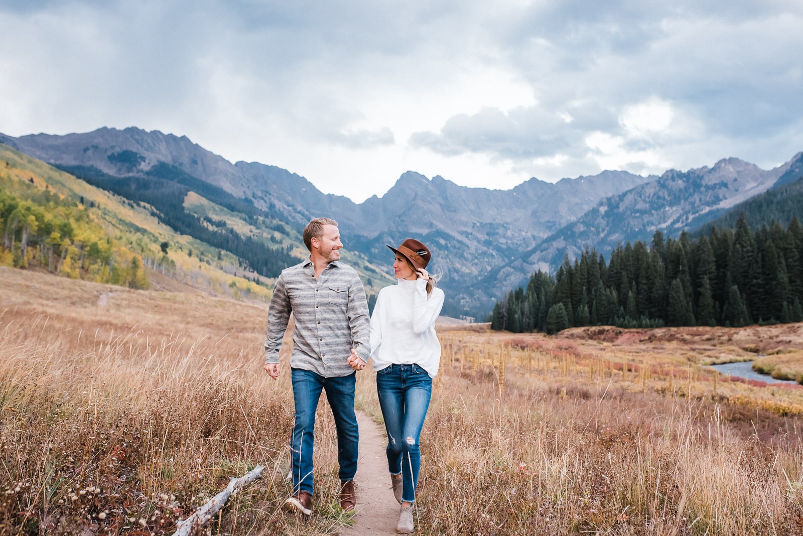 Couple runs among autumn in Colorado mountains